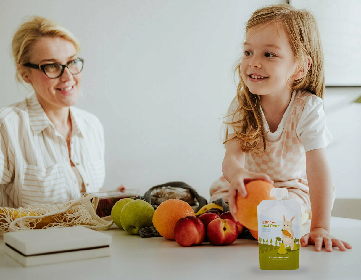 Mother and daughter with fruit and spouted pouch